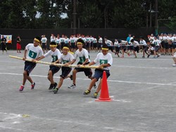 ５人で棒をもって、カラーコーンを回っている様子