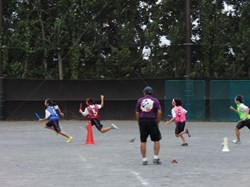 トラックにリレーのバトンを持った選手４人。デッドヒートの様子