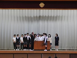 ステージ上に表彰される生徒が並び、校長が賞状を読んでいます。