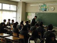 黒板に何か書きながら話す新聞記者さん