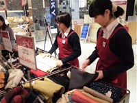 衣類のかごの整頓をする生徒2人