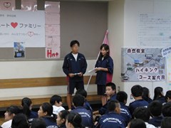 体育館で実行委員長の話を聞く生徒たち