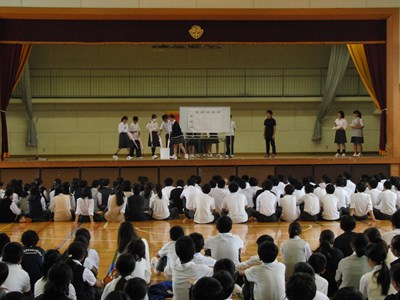 ステージ中央の傘に5人の合唱委員が手を伸ばしています